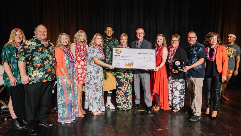 A group of people from The Chill Project receive a giant check from Juju Smith-Schuster